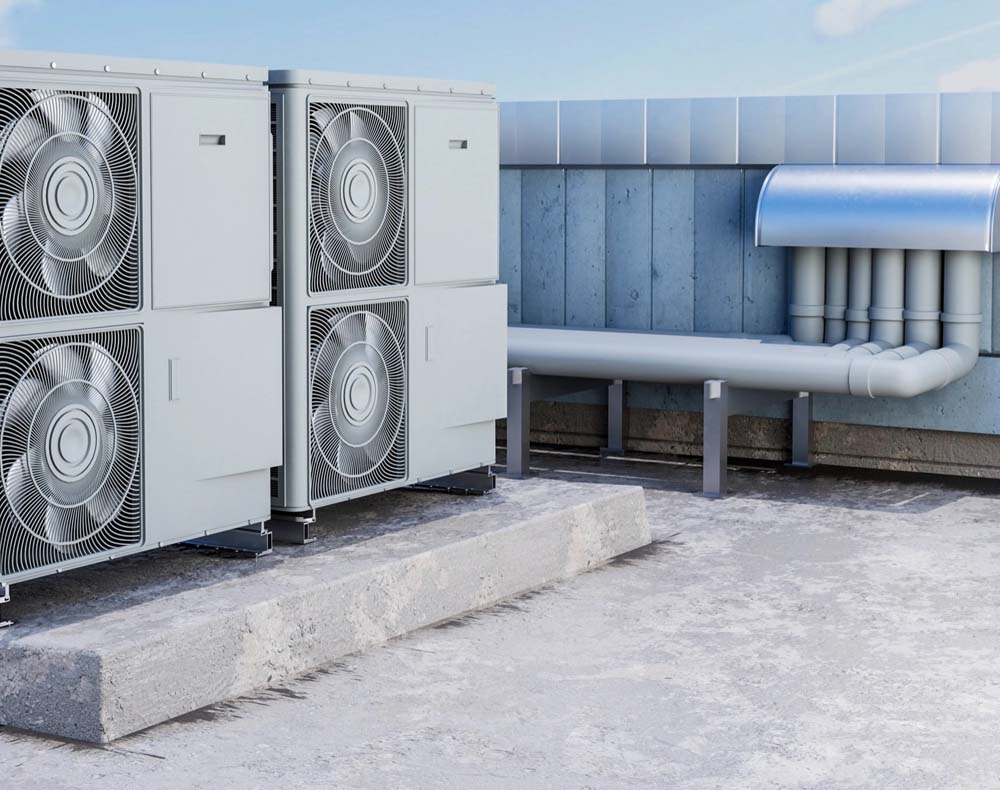 Four air conditioning units on a rooftop with a metal duct and pipes against a blue sky background.